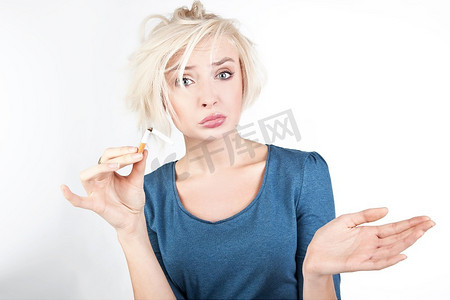烟香烟摄影照片_忧心忡忡的金发女子手里拿着一支破烟