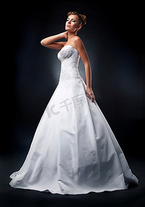 婚礼-年轻漂亮的金发新娘穿着白色婚纱站在领奖台上-摄影棚拍摄