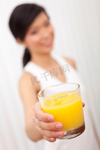 中国女孩摄影照片_一名亚裔中国女孩拿着一杯橙汁对着镜头