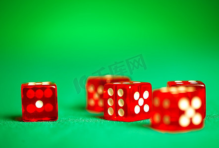 博饼骰子图摄影照片_绿色布料上的红色骰子。