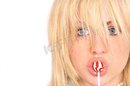 一个年轻漂亮的模特儿在吮吸红白相间的棒棒糖