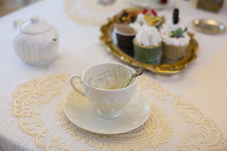 欧式餐桌摄影照片_餐桌假花插花烛台咖啡下午茶鲜花欧式装修蛋糕甜品