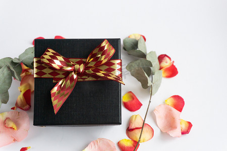 纯色红色背景摄影照片_鲜花玫瑰花瓣庆祝日浪漫布置礼品氛围礼物红色礼品