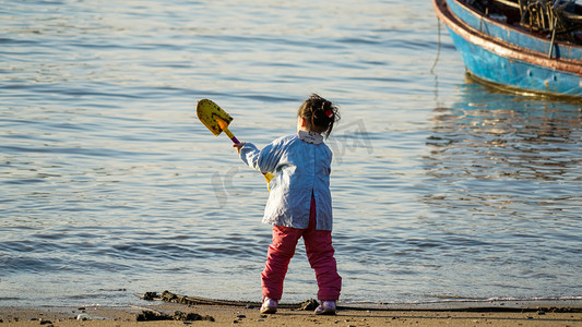 玩耍的小朋友摄影照片_海边沙滩上玩耍的小女孩