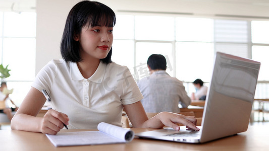 书写女孩摄影照片_图书馆看书的女大学生学习阅读书写作业