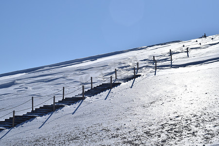 攀爬雪山摄影照片_雪山山路下雪