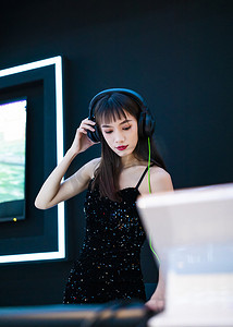 调音师摄影照片_穿着性感黑色吊带裙的女DJ在打碟3