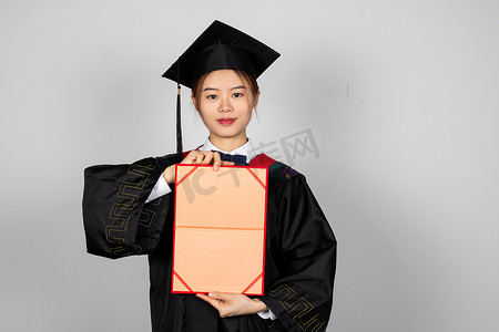 手拿毕业证书黑板穿学士服的大学毕业生