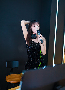 dj酒吧摄影照片_穿着性感黑色吊带裙的女DJ在打碟j