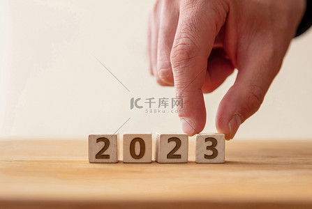 2023目标背景图片_2023新年快乐庆祝理念。2023数字在木制立方体上与手指接触数字3 。新计划，商业，事业，目标，成功。问候语.