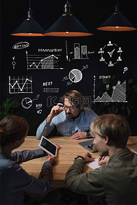 女商人在平板电脑上显示的东西, 她的伙伴和坐在桌子上, 与商业图标的头