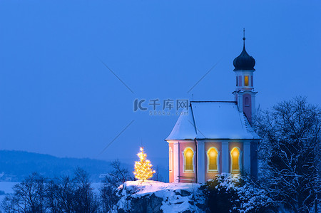 浪漫的圣诞礼拜堂，山上雪地里点亮的树