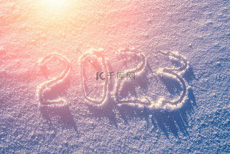 雪地上的数字2023被阳光照亮了。新年和圣诞节的概念.          