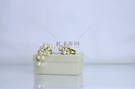 黄金珠宝背景图片_珍珠黄金珠宝在礼品盒上珍珠胸针珍珠环