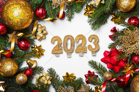 球球礼物背景图片_祝您2023年新年快乐。白色背景上的烛光和圣诞树、球、礼物的布局。闭合和复制空间，选定焦点.
