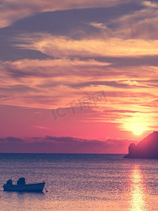 风景日出或日落在海面，船停泊在海湾，希腊。海面上的日出或日落