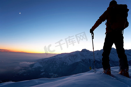 黄昏时分，一位勇敢的野外滑雪者在荒野中走了一整天后到达了山顶。探险探险的概念。