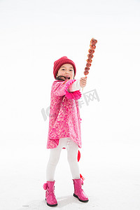 糖葫芦串摄影照片_欢乐的小女孩吃糖葫芦