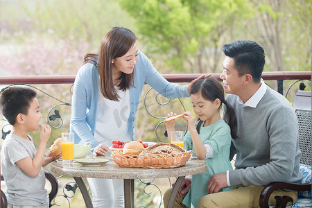 阳台人摄影照片_幸福家庭在阳台吃早餐