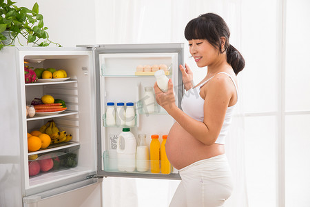 孕妇打开冰箱拿牛奶