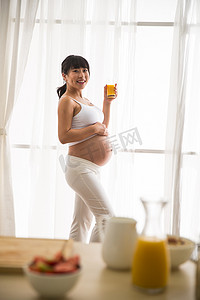 创意橙汁海报摄影照片_孕妇喝果汁