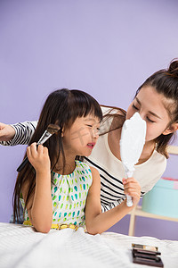 拿化妆刷摄影照片_妈妈与女儿在化妆