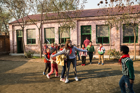 乡村教师和小学生在学校里做游戏