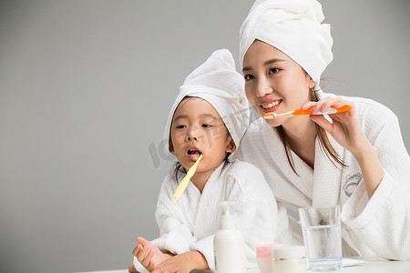 儿童的刷牙摄影照片_穿着浴袍的母女刷牙