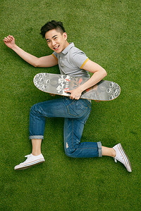 躺着的人像摄影照片_时尚活力的青年男人玩滑板