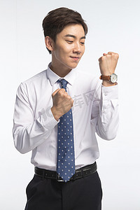 扭曲的时间摄影照片_戴着腕表的商务青年男人