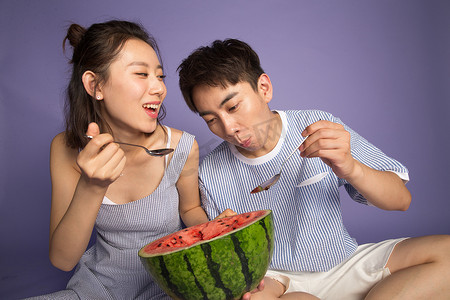 爱吃的表情摄影照片_时尚青年男女吃西瓜