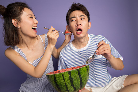 爱吃的表情摄影照片_青年男女吃西瓜
