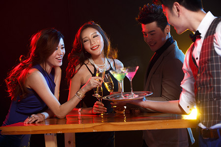 香槟高脚杯摄影照片_青年男女在酒吧喝酒