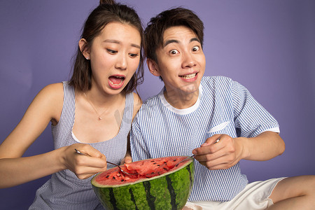 爱吃的表情摄影照片_时尚青年男女吃西瓜