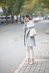 低头交流摄影照片_青年女人在路边等出租车