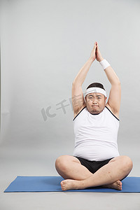 肥胖的青年男人在做瑜伽