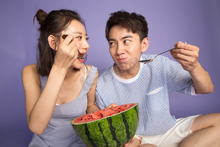 爱吃的表情摄影照片_青年男女吃西瓜