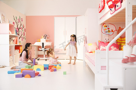两个小女孩和妈妈在卧室玩耍