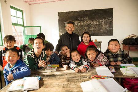 贫穷乡村摄影照片_乡村男教师和小学生在教室里
