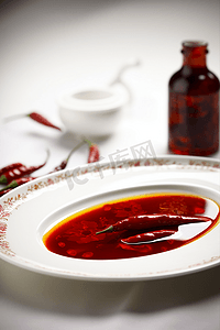 红色中国梦云摄影照片_放在瓷盘里的中国四川辣椒酱和红辣椒
