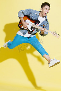 色彩鲜艳摄影照片_青年男人弹吉他