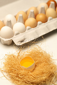 物体破碎摄影照片_一盒完整的鸡蛋和巢里破碎的鸡蛋