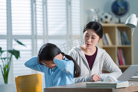 母女争吵摄影照片_年轻妈妈和做作业的女儿生气