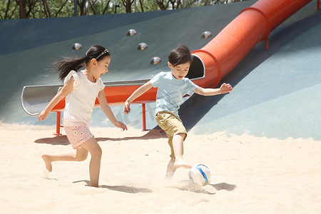彩色游乐场摄影照片_儿童在沙子里踢球