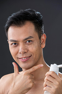 护肤膏摄影照片_拿着剃须膏做手势的中年男人