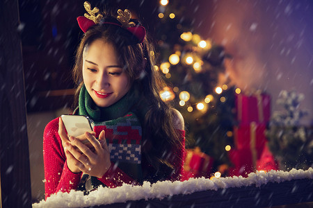 下雪青年摄影照片_漂亮可爱的年轻女孩在家使用手机