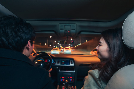 车窗车灯摄影照片_夜晚驾驶汽车出行的青年伴侣