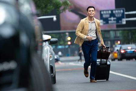 奔跑的人物商务摄影照片_马路上拉着行李追赶汽车的商务男子