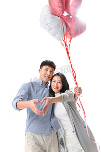 彩色爱心背景摄影照片_浪漫情侣拿着心形气球