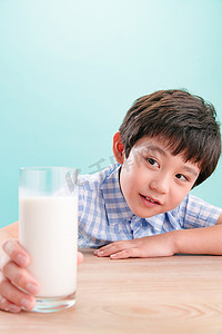 小男孩看着一杯牛奶